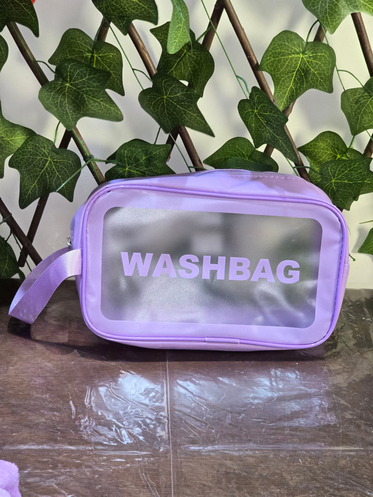 BioCode purple transparent washbag with a wrist strap, perfect for organising beauty and self-care essentials.