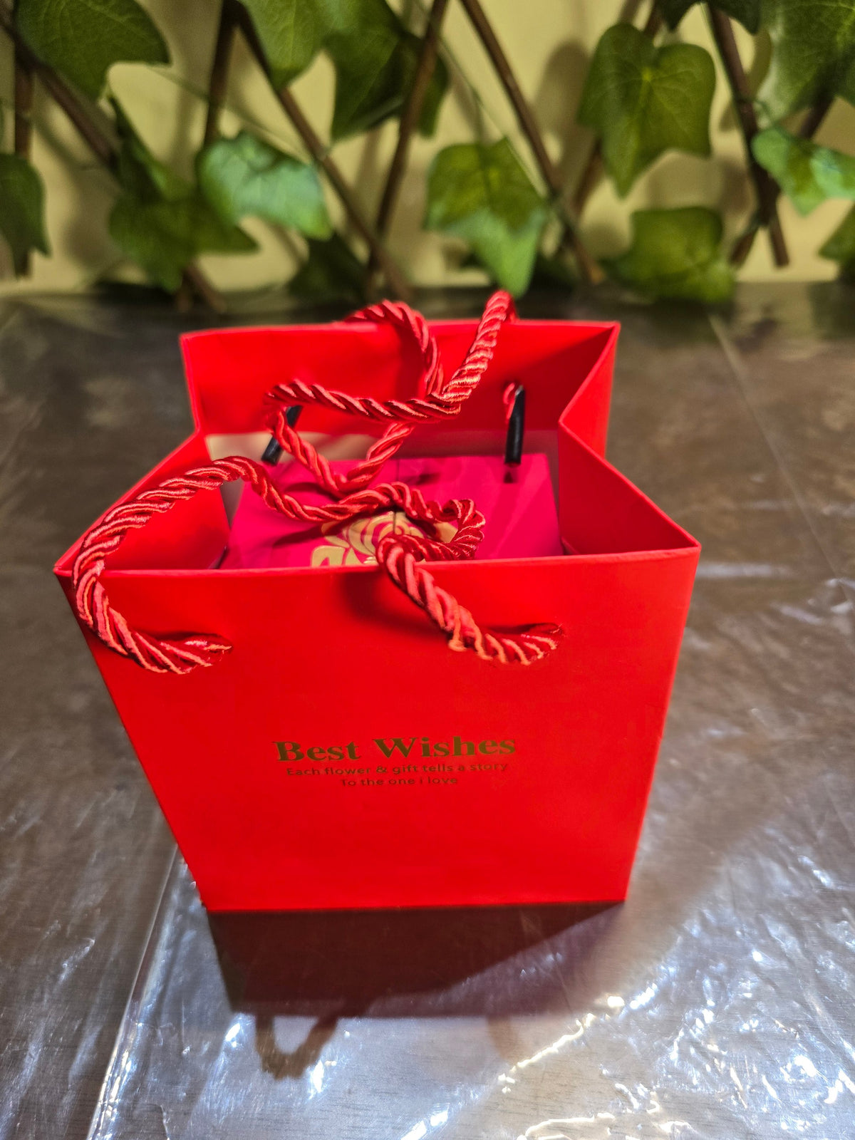 BioCode red gift bag with Best Wishes text and rope handles, containing a romantic jewellery box with preserved rose.