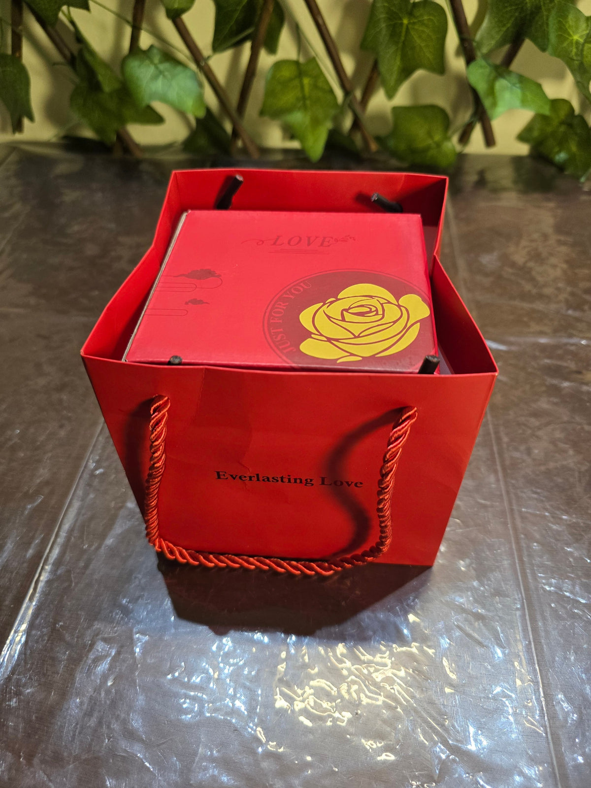 BioCode red gift bag containing a preserved rose jewellery box with gold rose emblem and Everlasting Love text