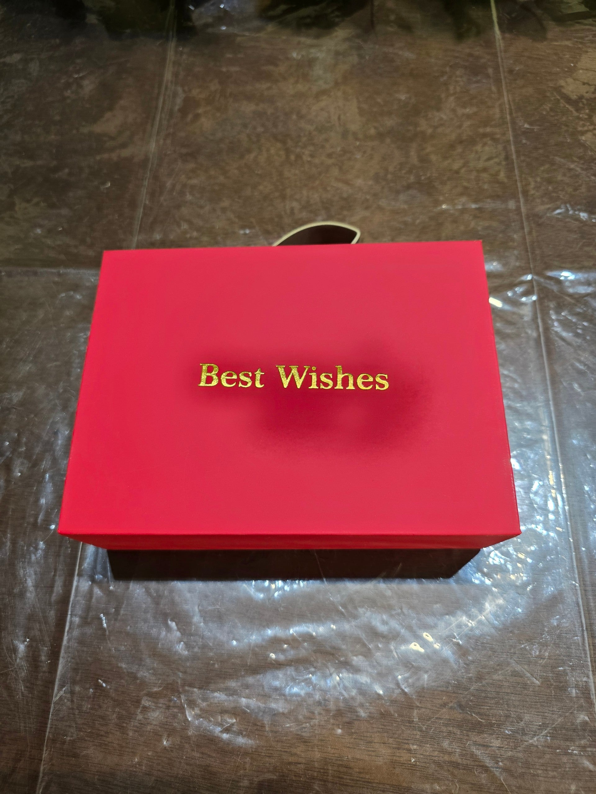 BioCode red gift box with Best Wishes in gold foil lettering, featuring a carry handle for jewellery presentation.