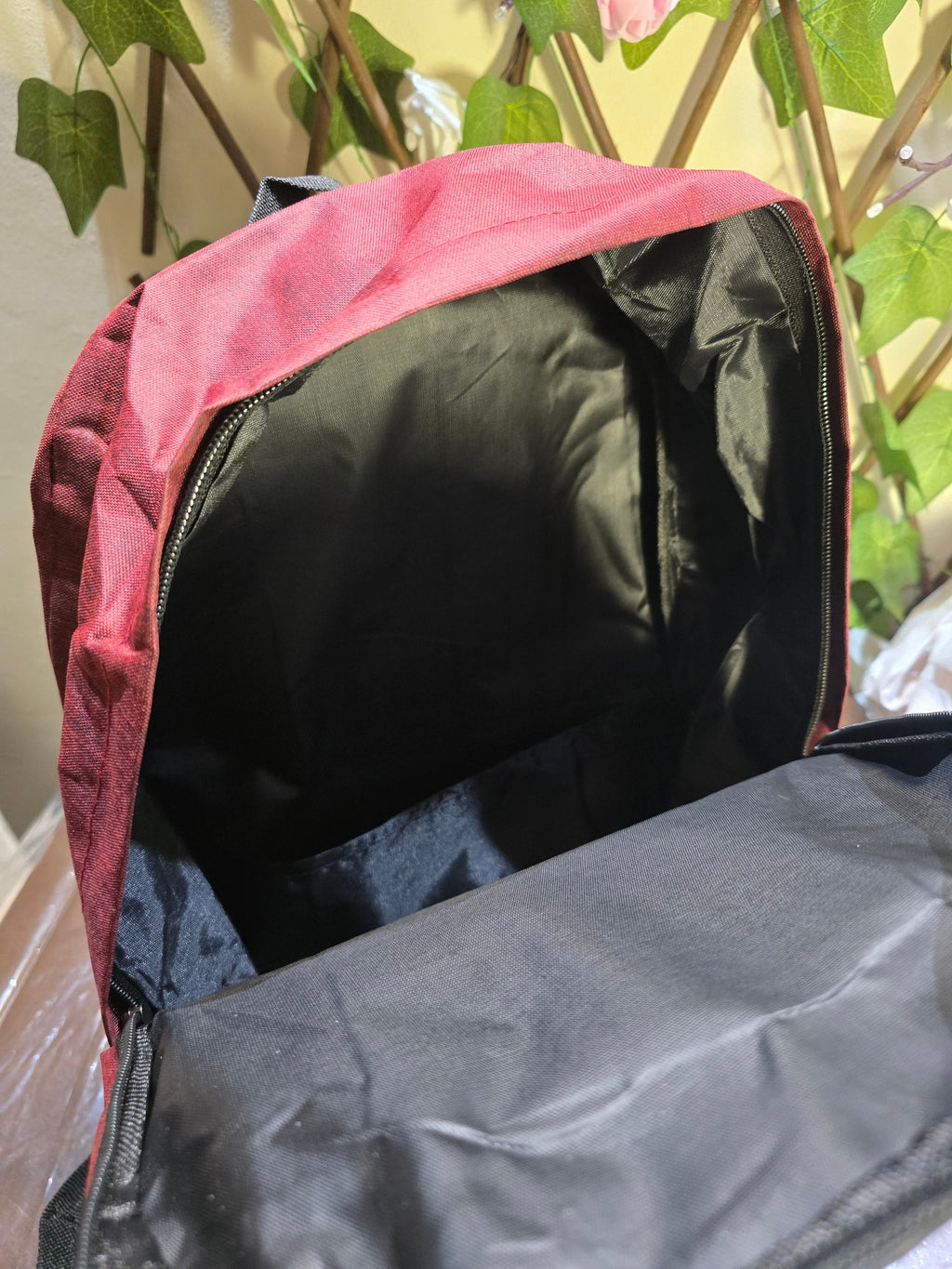 BioCode deep red laptop backpack with an open main compartment, black interior lining, and durable fabric construction.