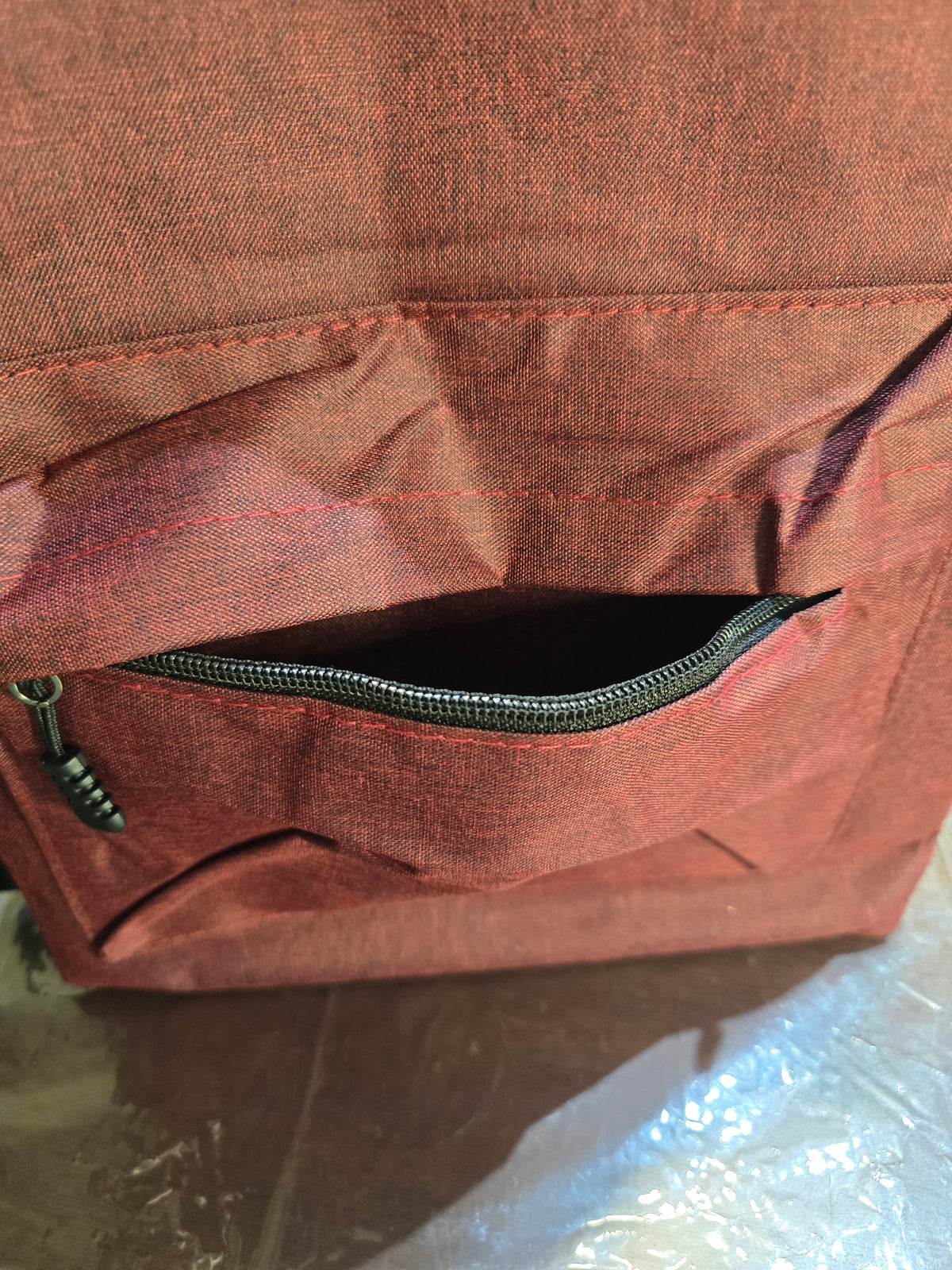 BioCode deep red fabric laptop backpack featuring a secure front zip pocket with durable stitching