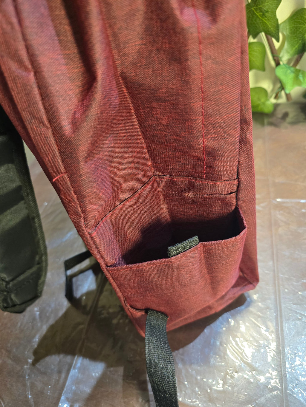 BioCode deep red laptop backpack side view showing a durable fabric side pocket for a water bottle