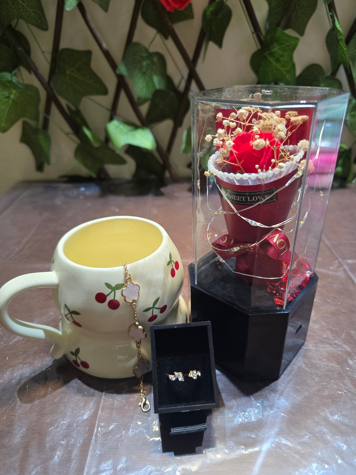 BioCode romantic gift set with cherry print mug, gold floral bracelet, crystal earrings, and preserved red rose case.