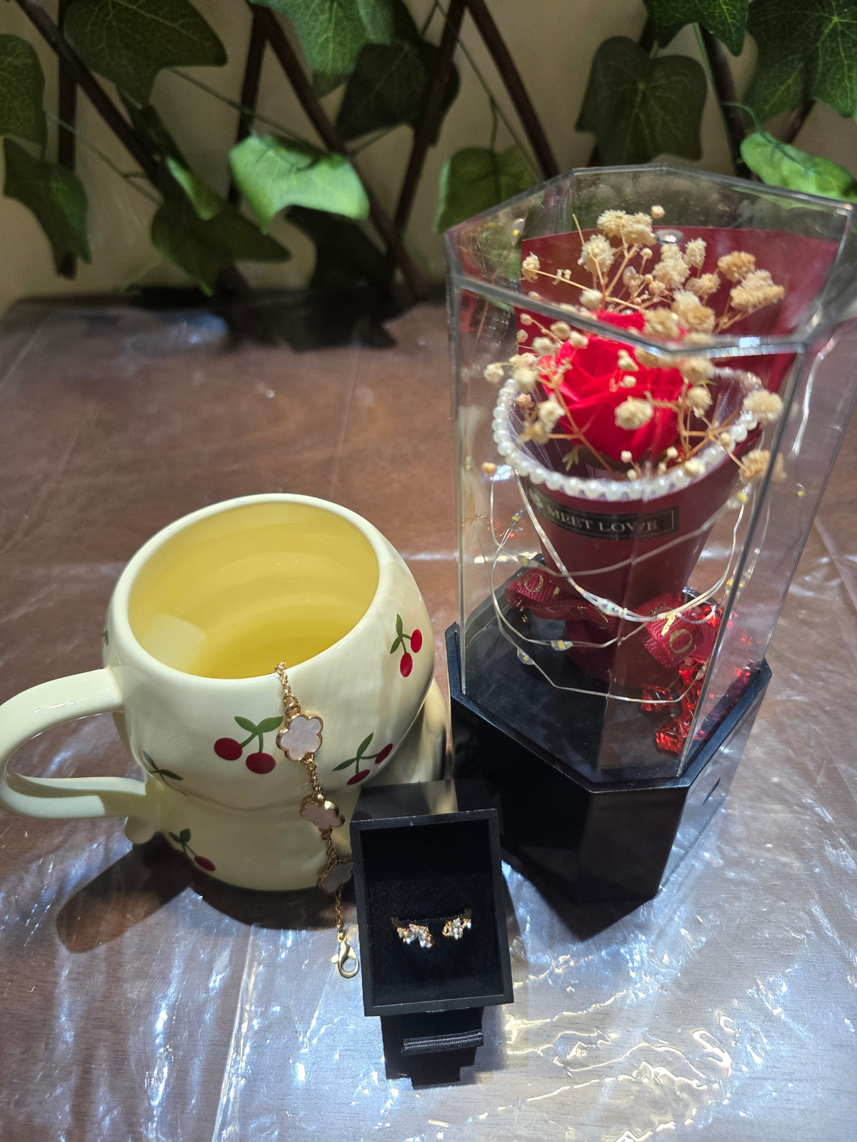 BioCode romantic gift set with cherry print mug, gold floral bracelet, crystal earrings, and preserved red rose case.