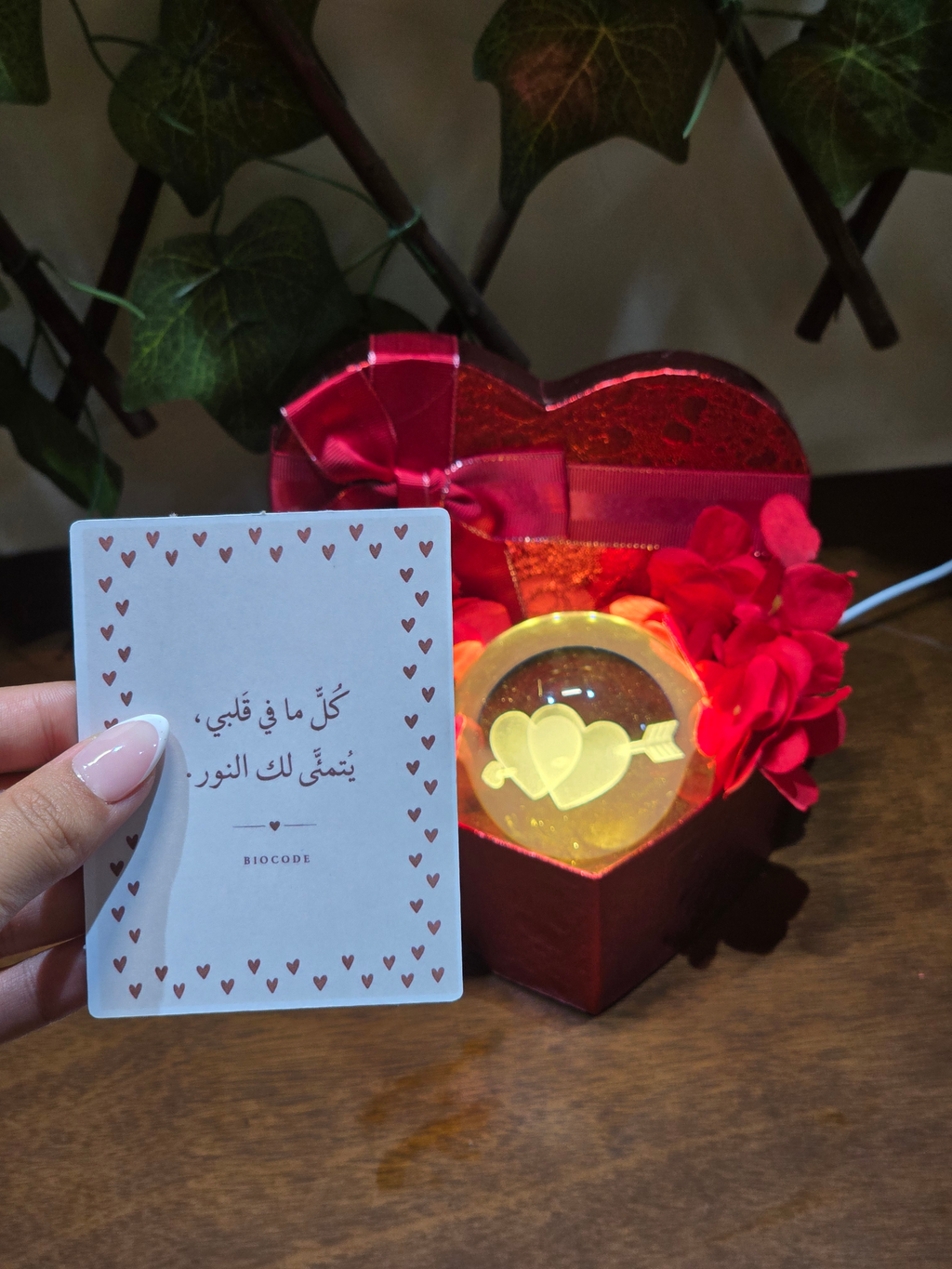 BioCode romantic gift set with a heart-shaped box, LED crystal ball, artificial flowers, and an Arabic greeting card.