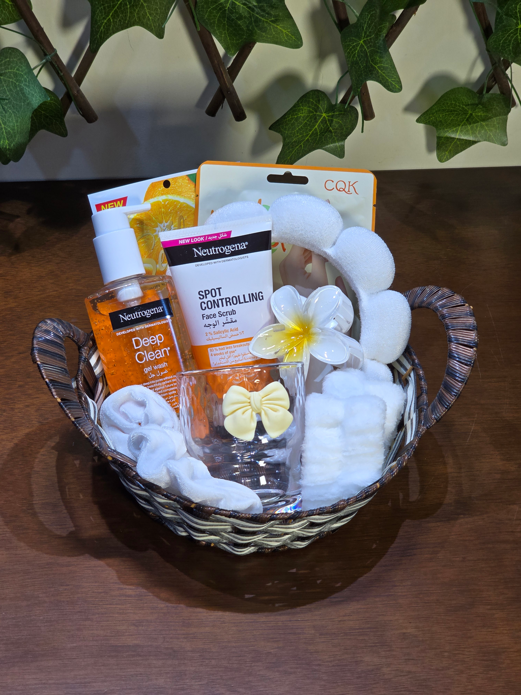 BioCode skincare gift basket featuring Neutrogena cleansers, plush cloud headband, wristbands, and decorative glass.