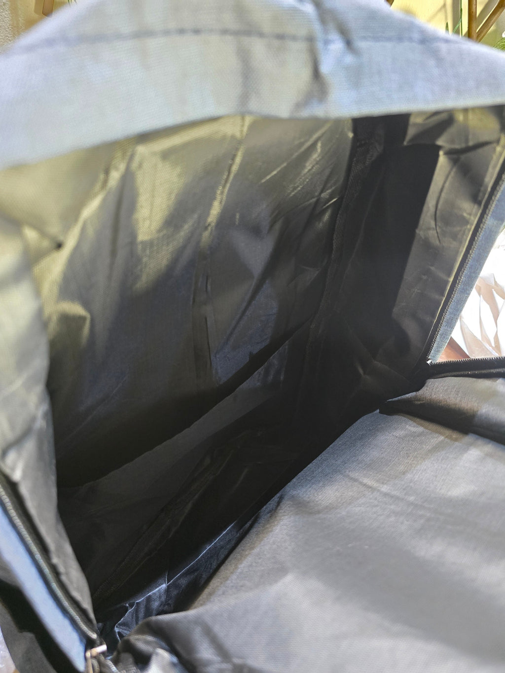 Interior view of the slate-blue BioCode backpack showing the spacious main compartment and durable fabric lining.
