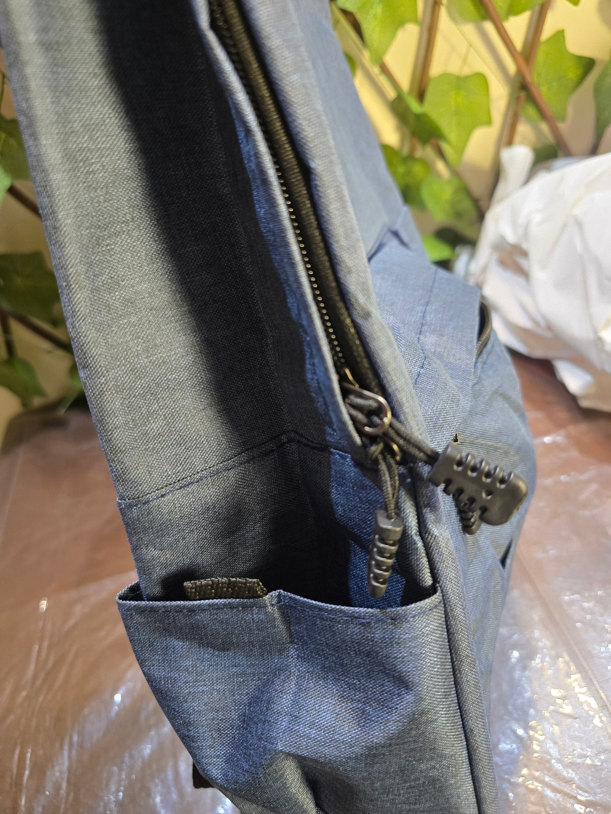 BioCode slate-blue textured fabric backpack with a side pocket and secure zip closure for daily use