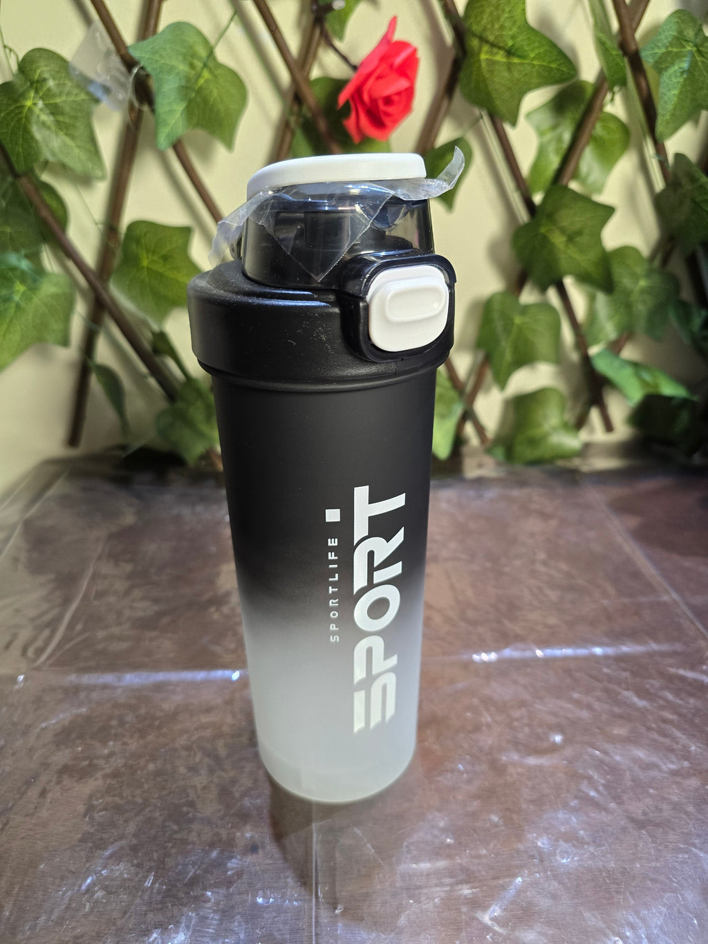 BioCode Sportlife shaker bottle with a black-to-clear gradient finish, featuring a secure white leak-proof lid