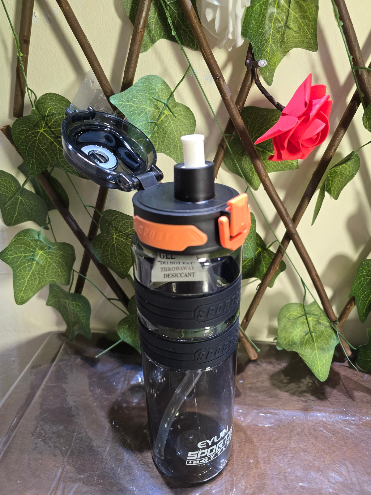 BioCode sports water bottle with a black leak-proof locking lid, straw mechanism, and textured grip in clear plastic