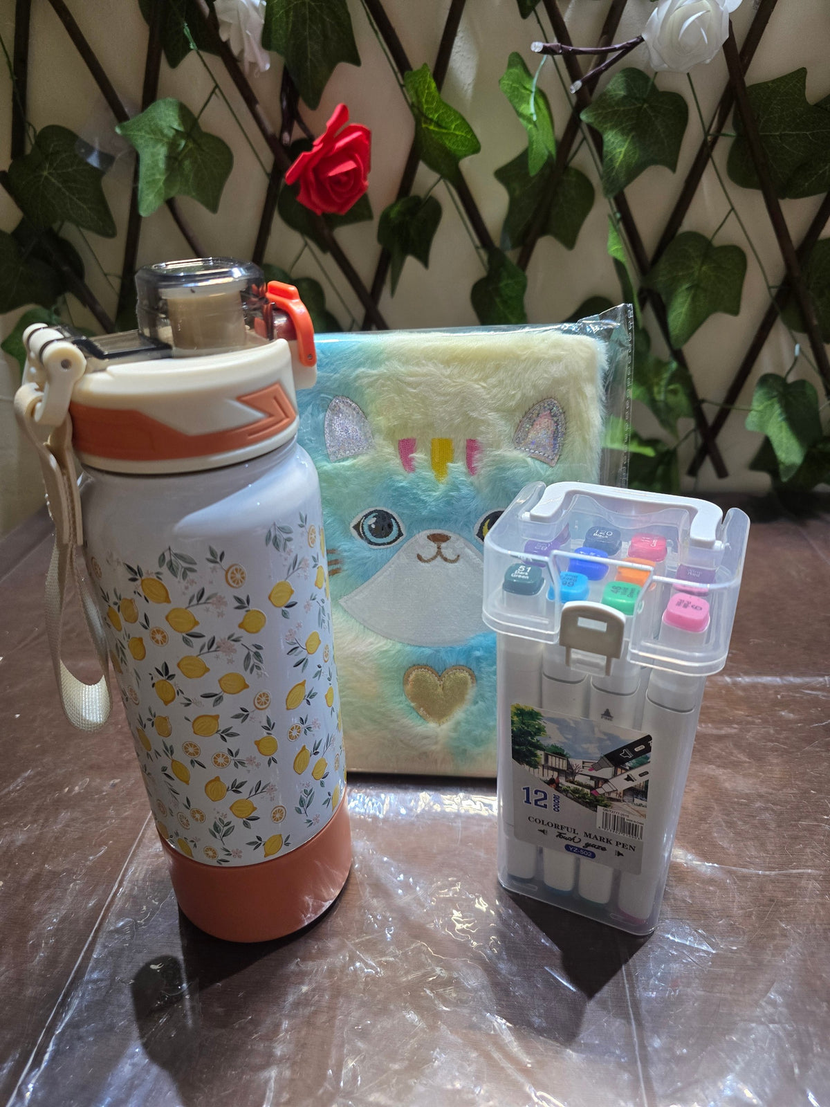 BioCode stationery set featuring a lemon-print water bottle, a plush cat notebook, and a 12-piece colourful marker set.