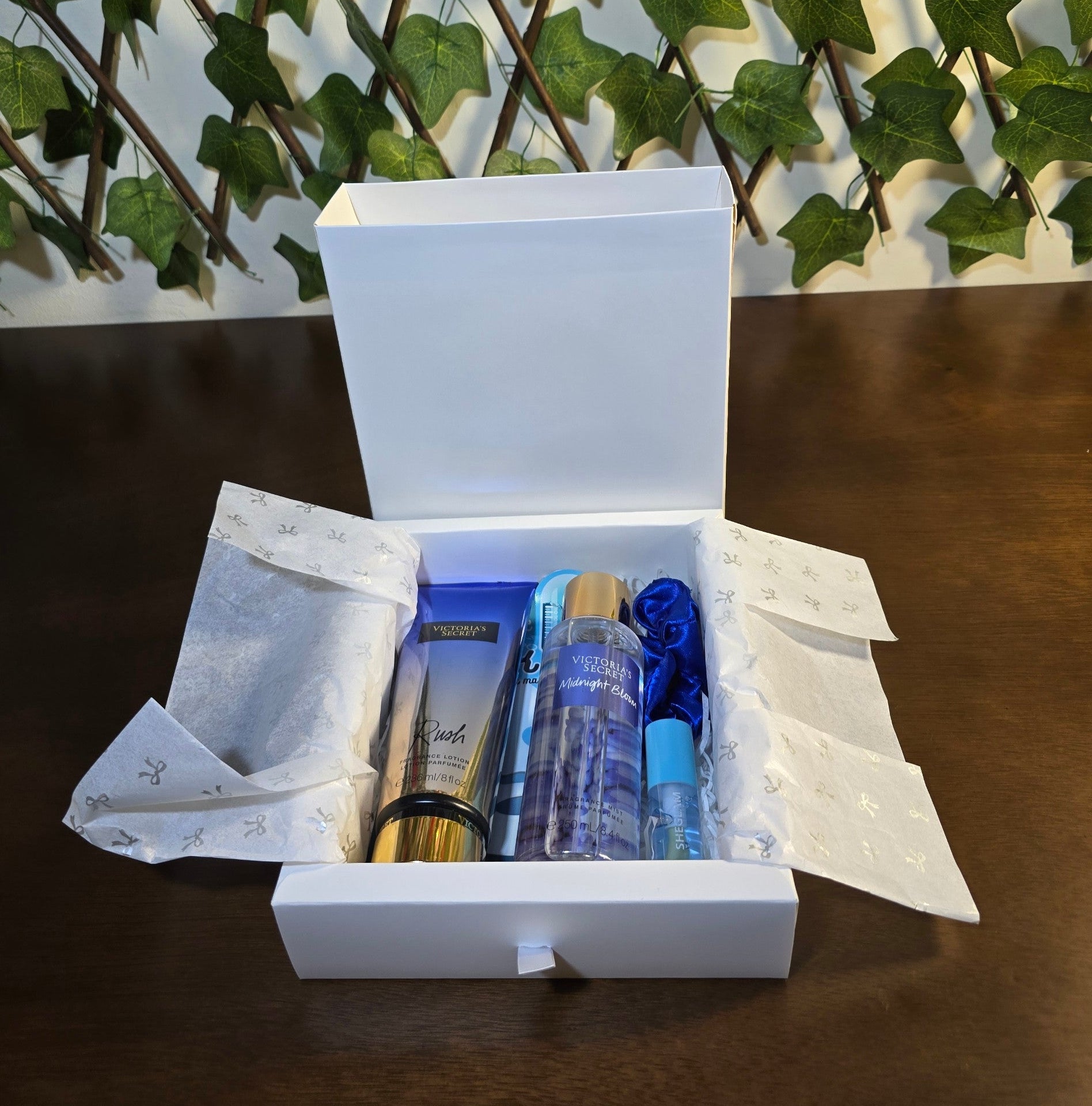 BioCode Victoria's Secret gift set featuring Rush lotion, Midnight Bloom mist, blue scrunchie, and lip care in a box.