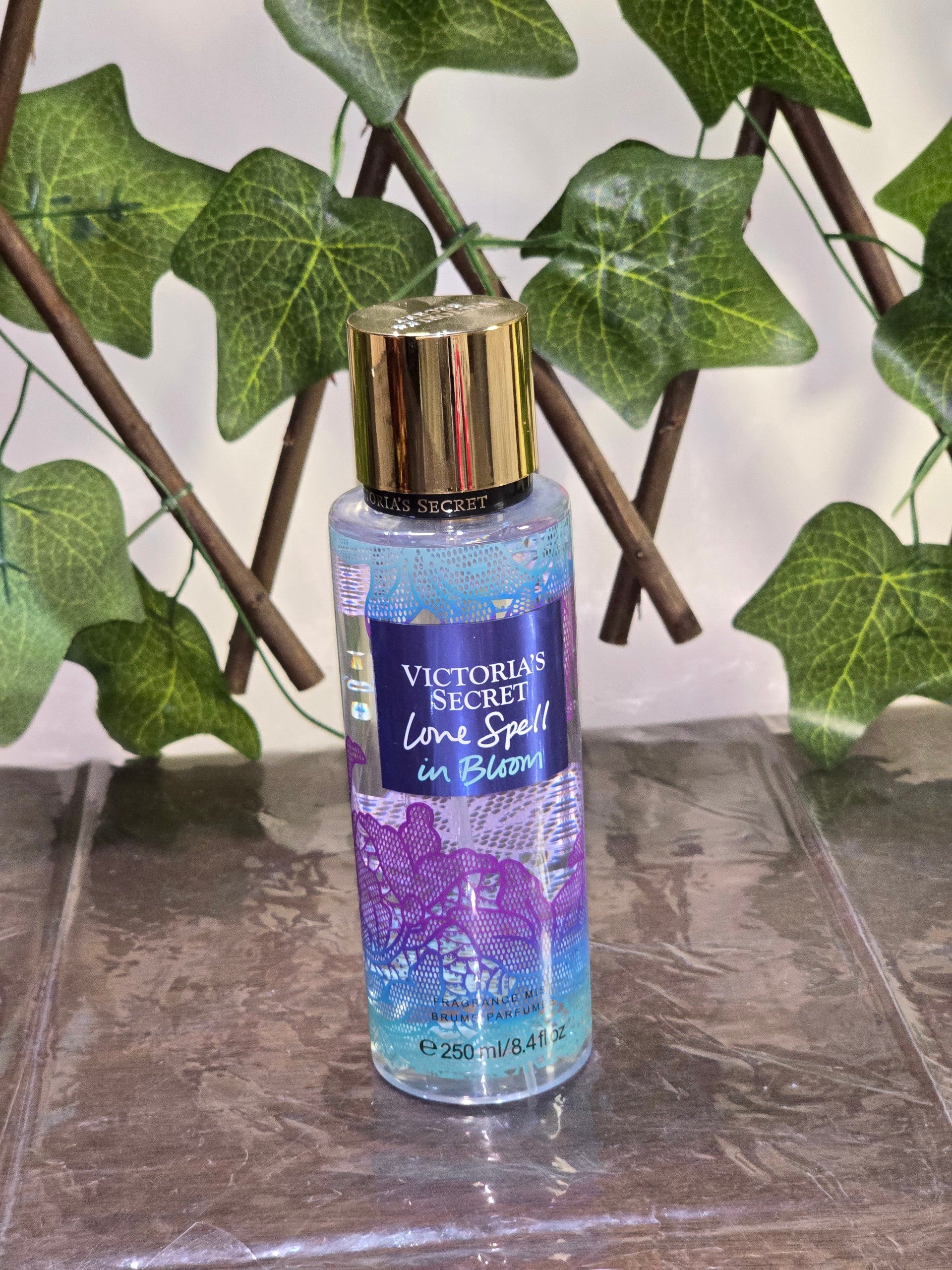 BioCode Victoria's Secret Love Spell in Bloom fragrance mist in a clear bottle with gold cap against ivy leaves