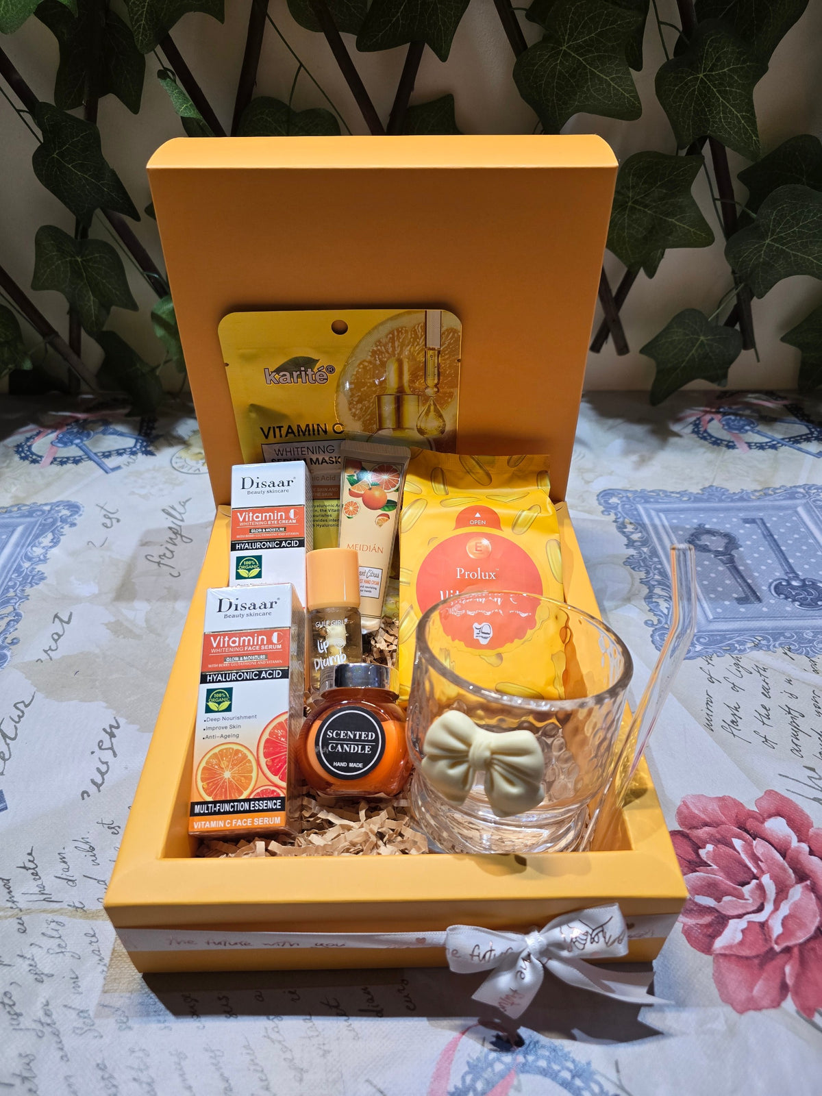 BioCode Vitamin C skincare and relaxation gift set featuring face serum, scented candle, and bow-detailed glass tumbler.
