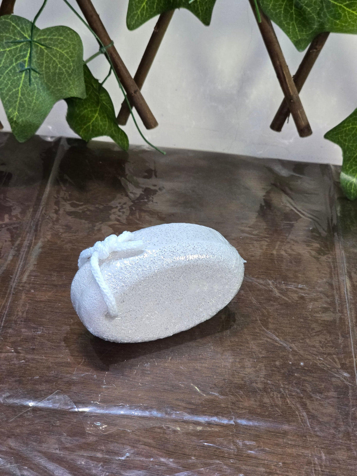BioCode white oval pumice stone with a hanging cord for exfoliating skin in a spa gift set